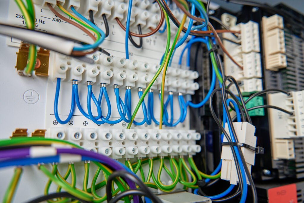 Colorful wires and components connected to terminal block in distribution box. Electrical circuit board with wiring and connections